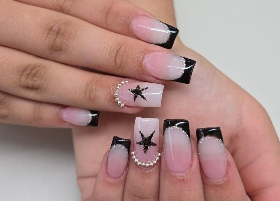 Chic black-tipped nails with star design at Millionaire Nails, Revesby, New South Wales, AU.