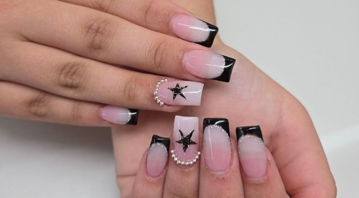 Chic black-tipped nails with star design at Millionaire Nails, Revesby, New South Wales, AU.