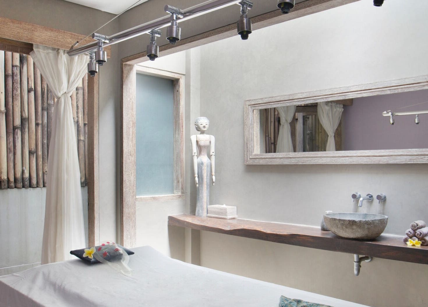 Tranquil treatment room at Mudara Spa in Bali, Bali, ID, featuring rustic decor and a soothing ambiance.