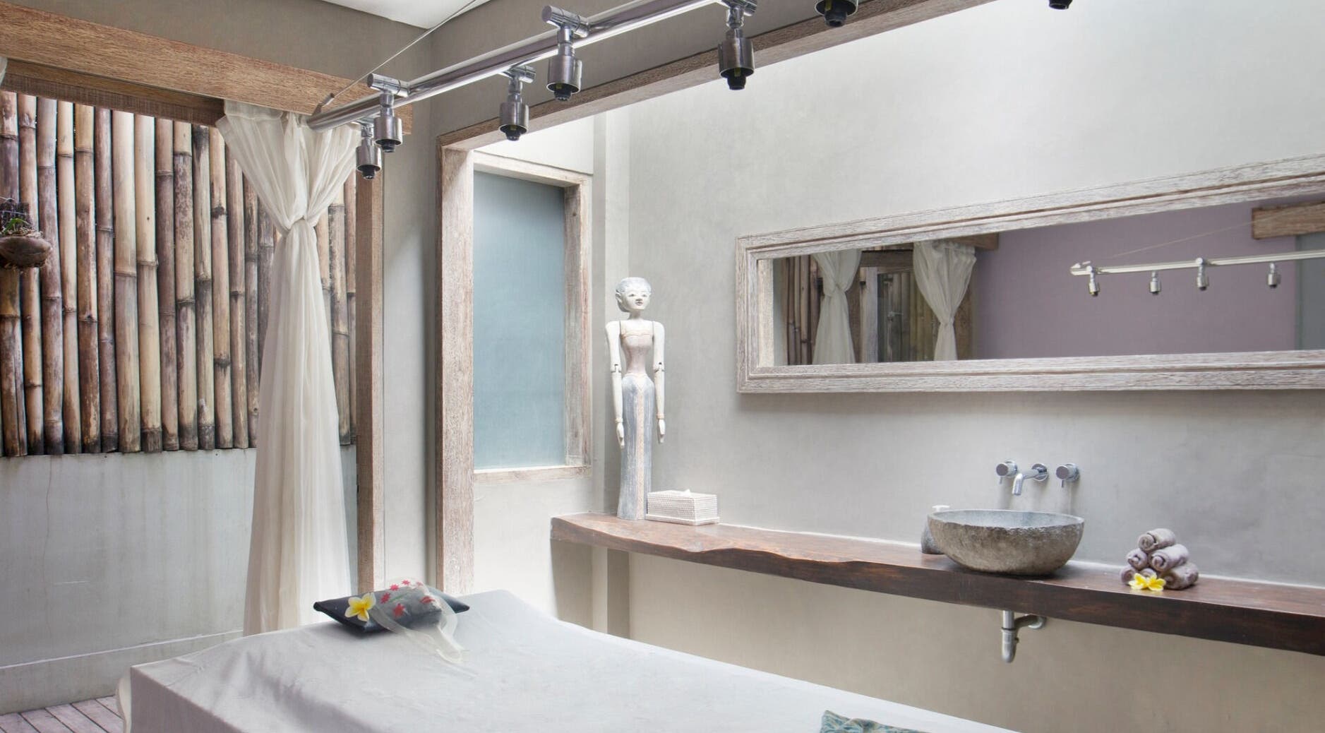 Tranquil treatment room at Mudara Spa in Bali, Bali, ID, featuring rustic decor and a soothing ambiance.