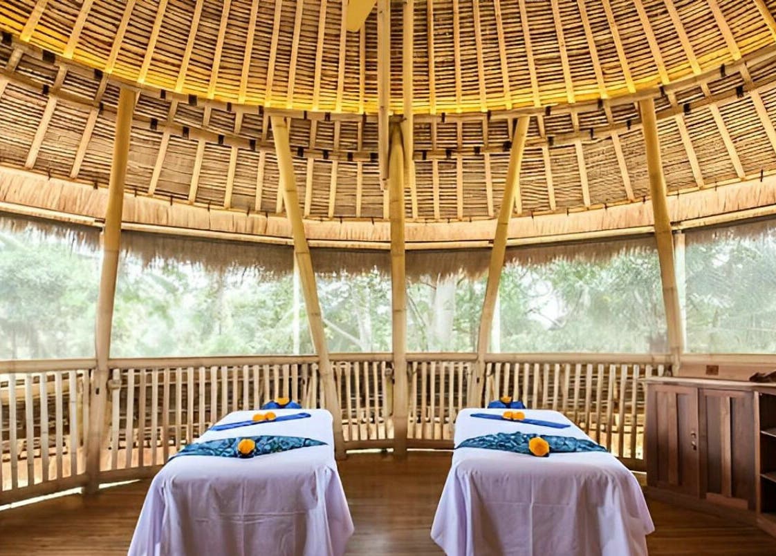 Relaxing massage room at Flying Bamboo Spa in Bali, Bali, ID with bamboo decor and twin massage tables.