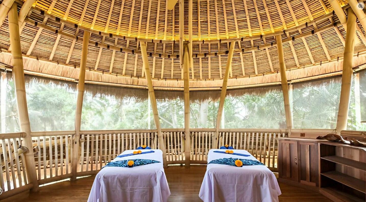 Relaxing massage room at Flying Bamboo Spa in Bali, Bali, ID with bamboo decor and twin massage tables.