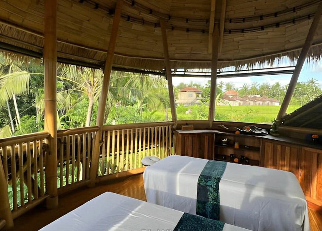Relaxing spa room at Flying Bamboo Spa, Bali, Bali, ID with scenic palm view and massage beds.