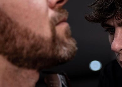 Barber at V29 Barbershop, Burton Upon Trent, England, shaping a client's beard with precision.