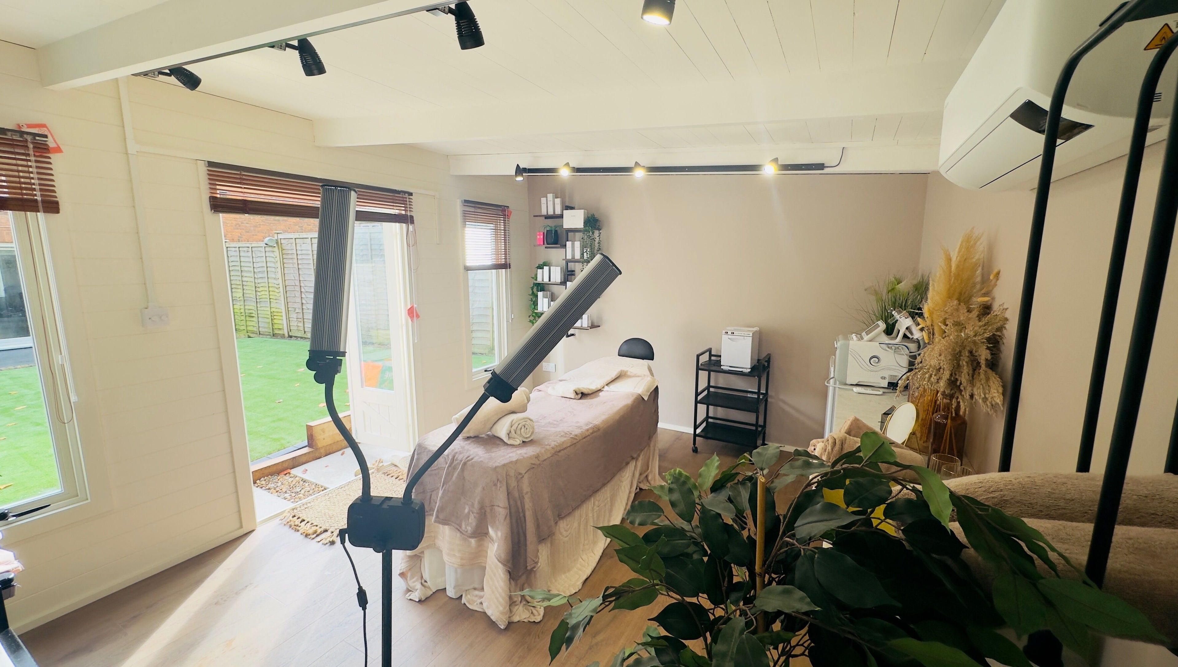 Elegant spa room at The Skin Chalet in Headley, England, GB with treatment bed and natural decor.