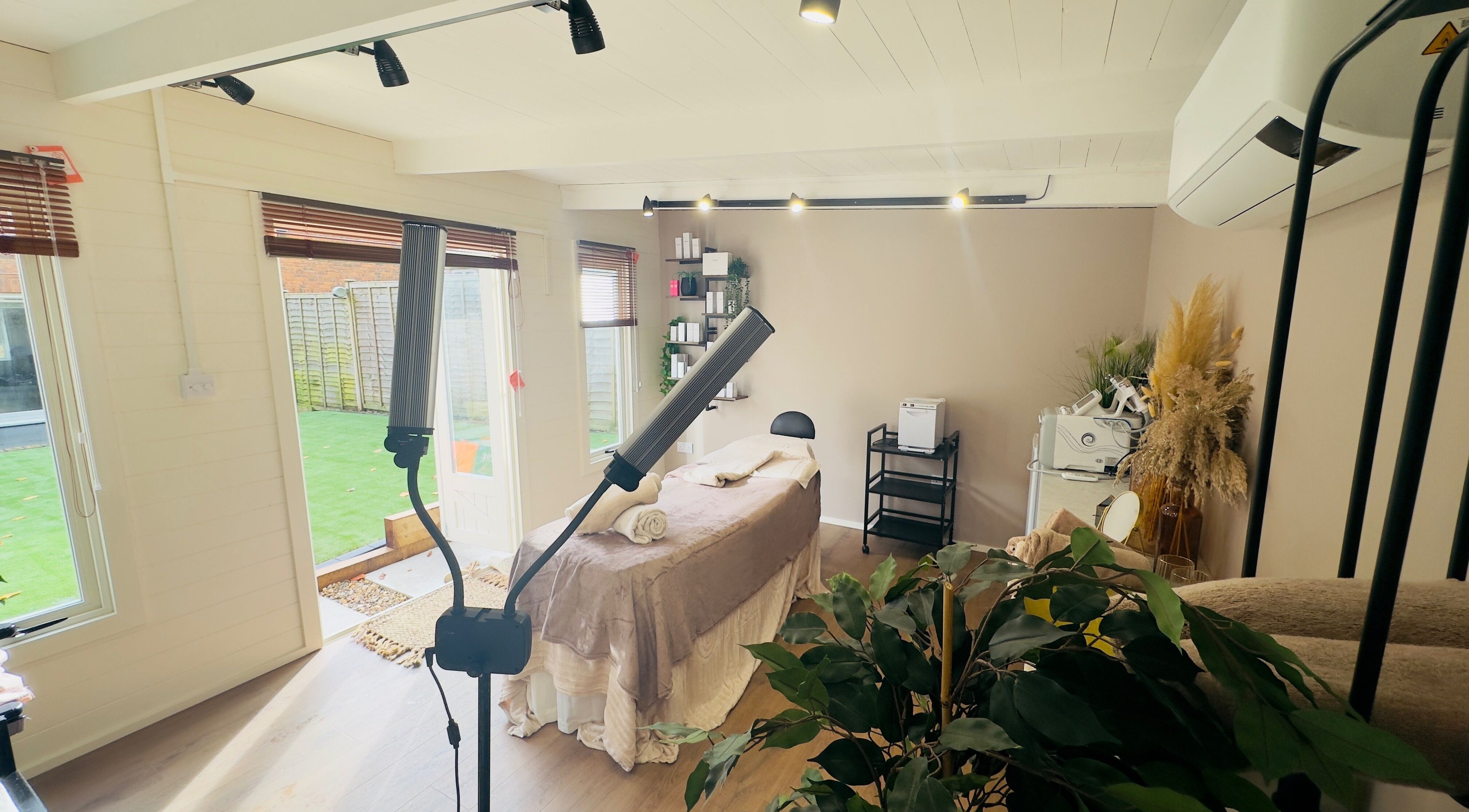 Elegant spa room at The Skin Chalet in Headley, England, GB with treatment bed and natural decor.