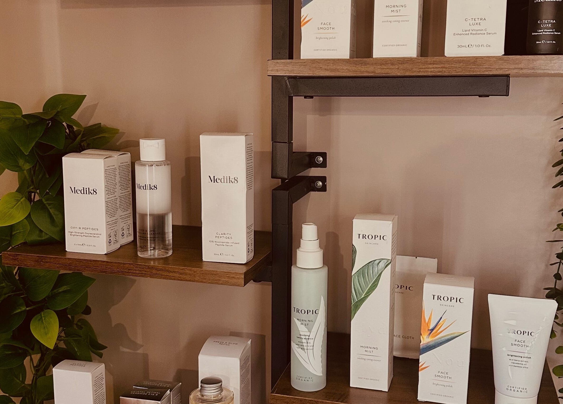 Skincare products on wooden shelves at The Skin Chalet, Headley, England, GB, showcasing premium beauty brands.