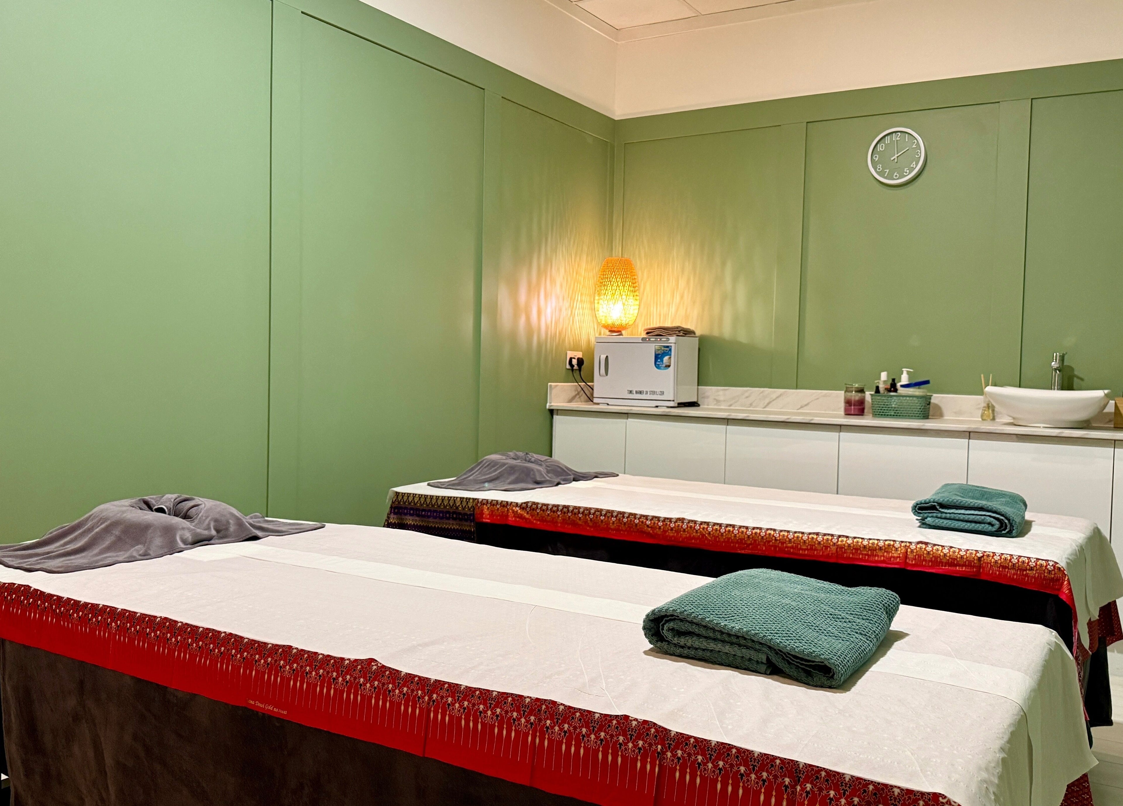 Tranquil massage room at Motion Remedy in Hornchurch, England, GB with green walls and ambient lighting.