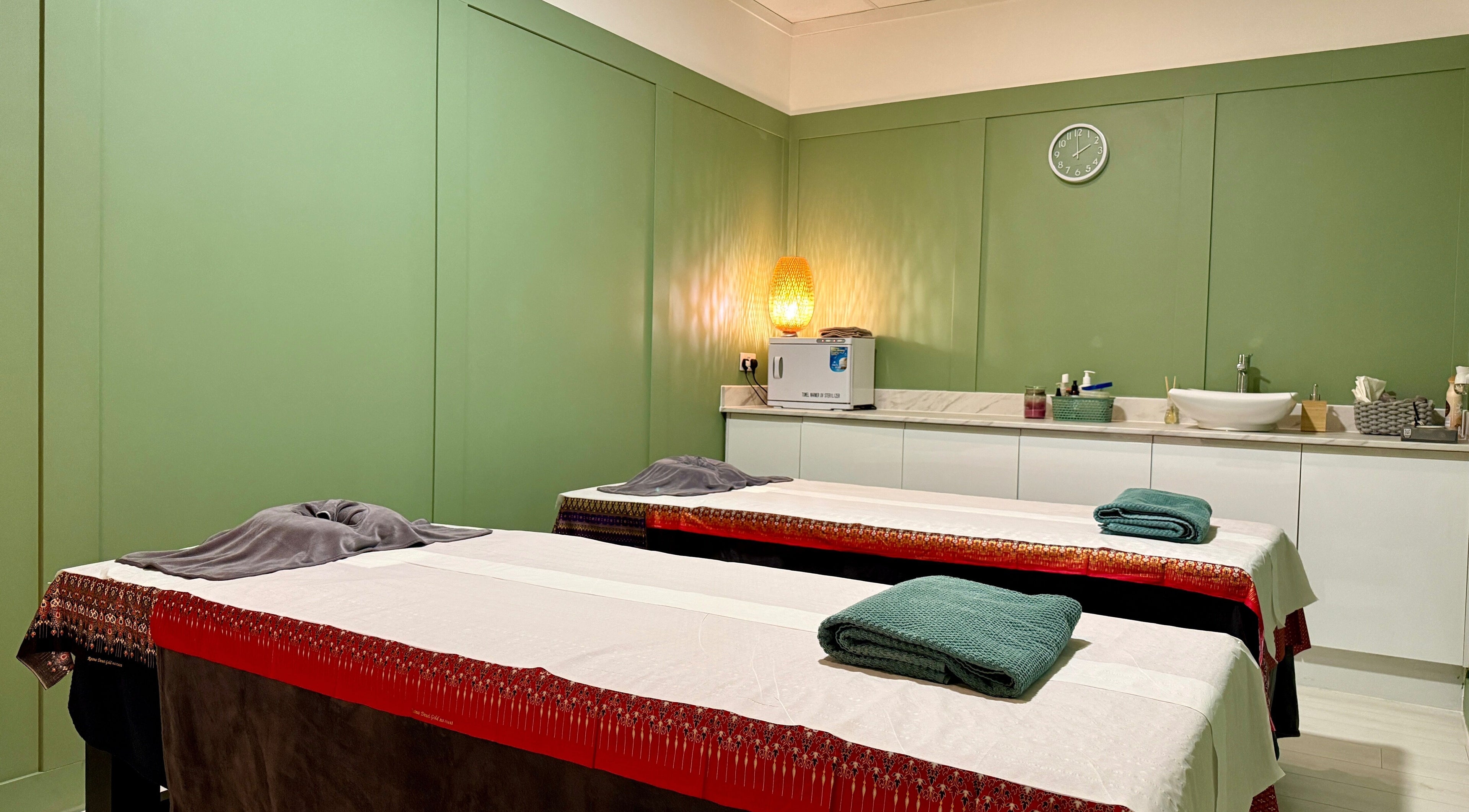 Tranquil massage room at Motion Remedy in Hornchurch, England, GB with green walls and ambient lighting.