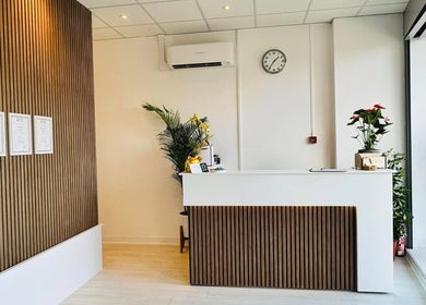 Modern reception area at Motion Remedy, Hornchurch, England, GB. Features sleek wood panels and indoor plants.