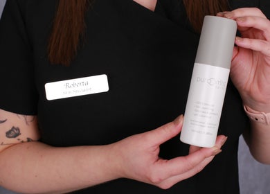 Skin specialist at Inner Glow, Milton Keynes, England, holding a skincare product.