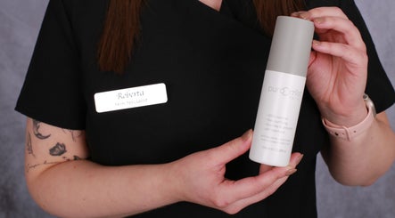 Skin specialist at Inner Glow, Milton Keynes, England, holding a skincare product.