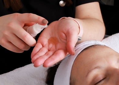 Therapist preparing oil at Inner Glow, Milton Keynes, England for a relaxing facial treatment.