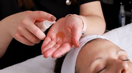 Therapist preparing oil at Inner Glow, Milton Keynes, England for a relaxing facial treatment.