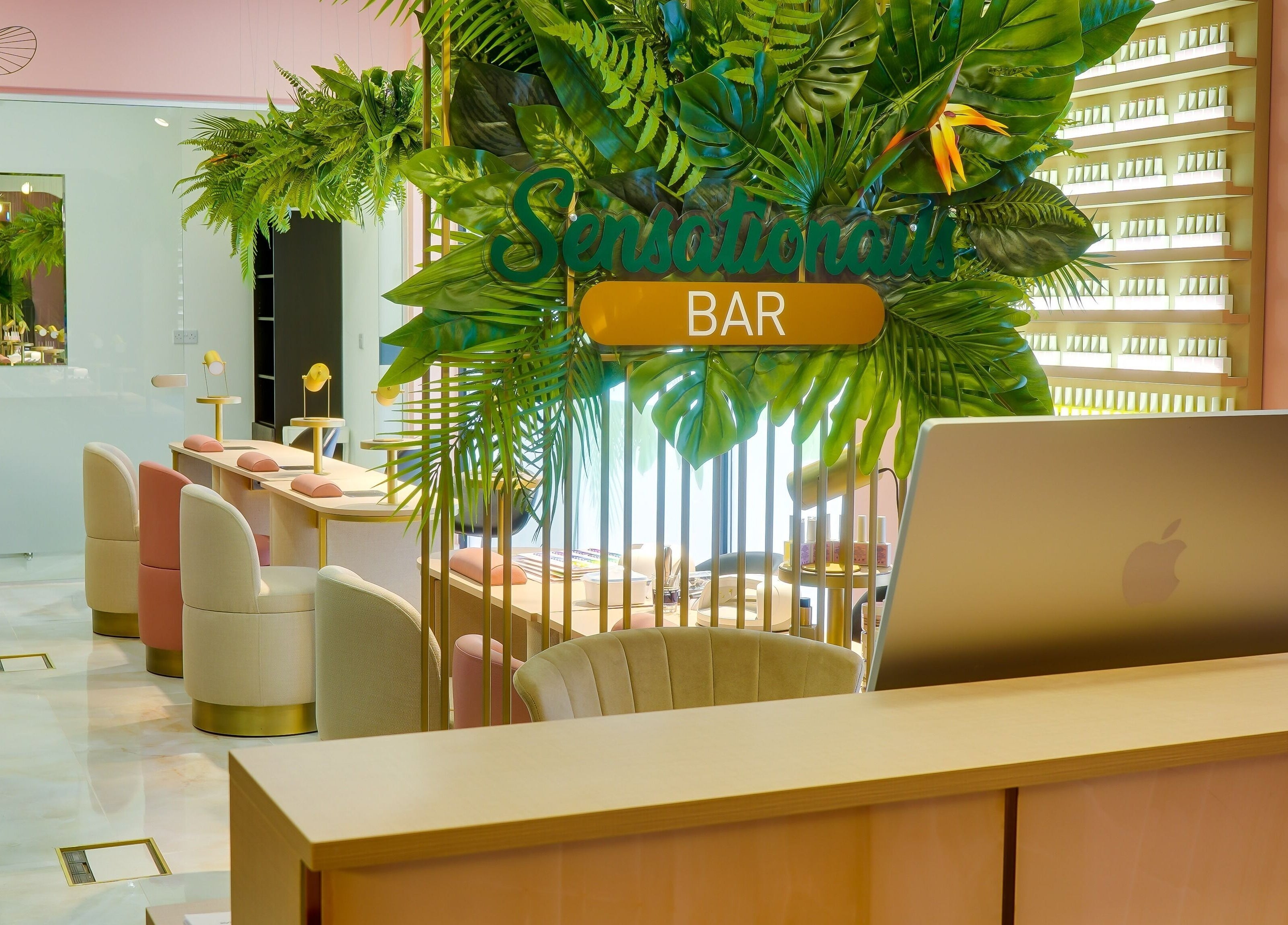 Interior view of Sensationails Bar in London, England, featuring modern decor and lush greenery.