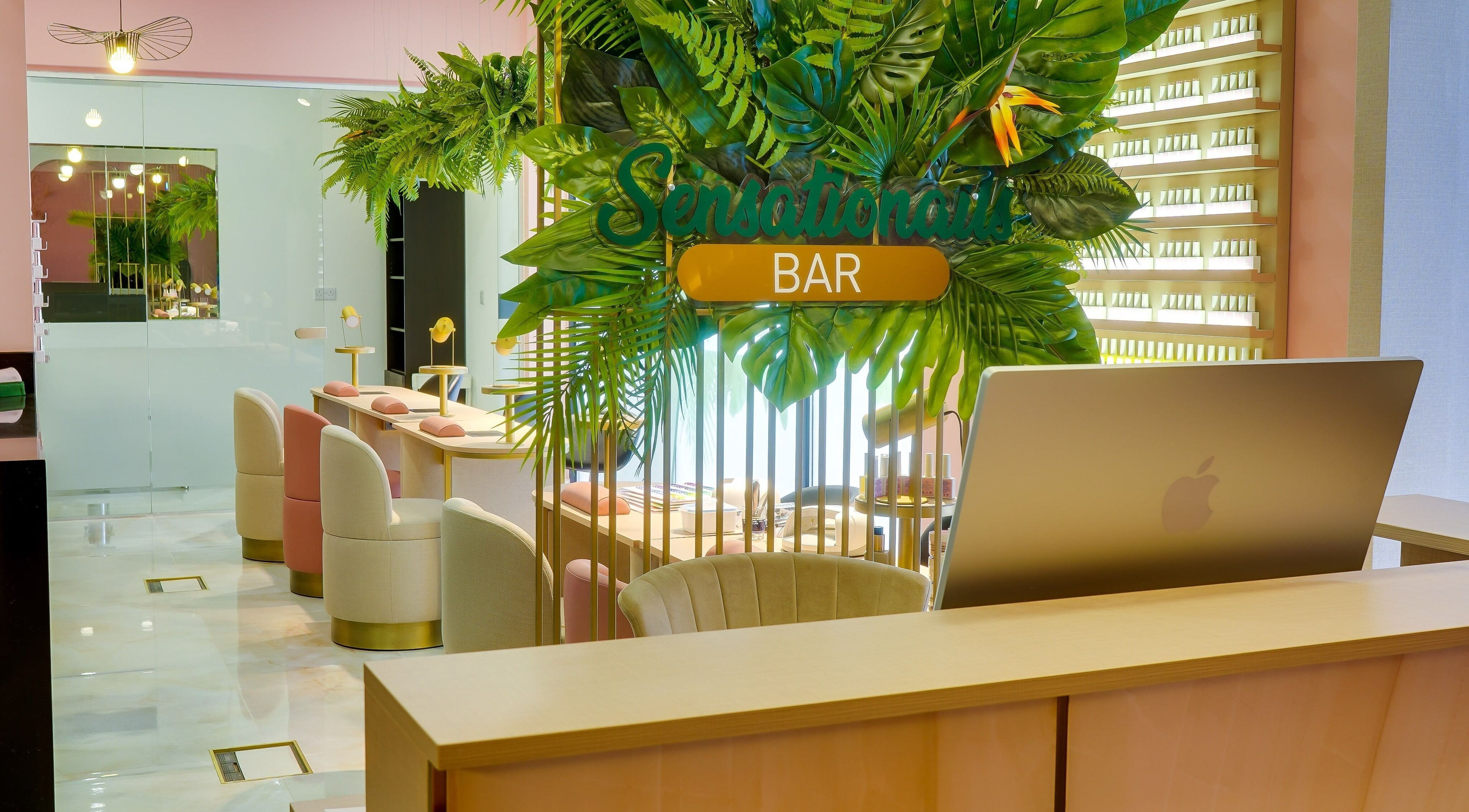 Interior view of Sensationails Bar in London, England, featuring modern decor and lush greenery.