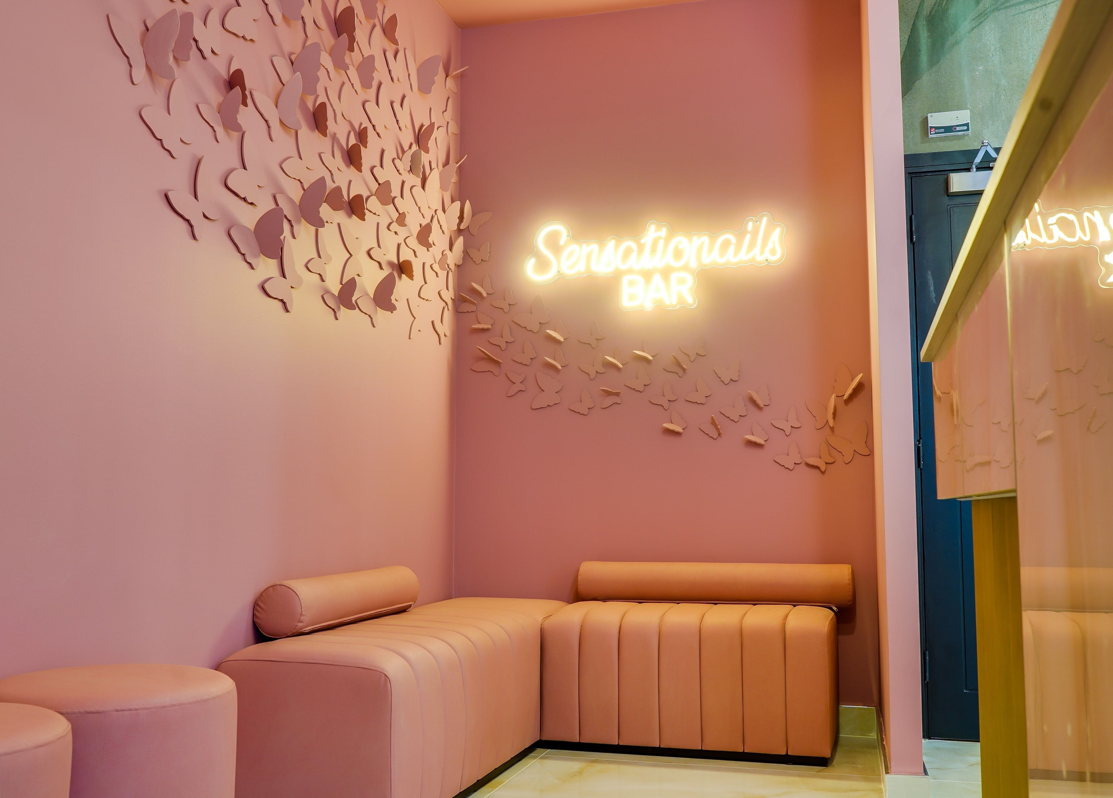 Elegant pink seating and neon sign at Sensationails Bar, London, England, GB.