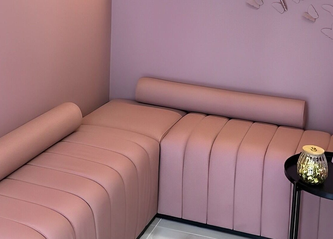 Elegant seating area at Sensationails Bar, London, England, GB with pink cushioned seats and decor.