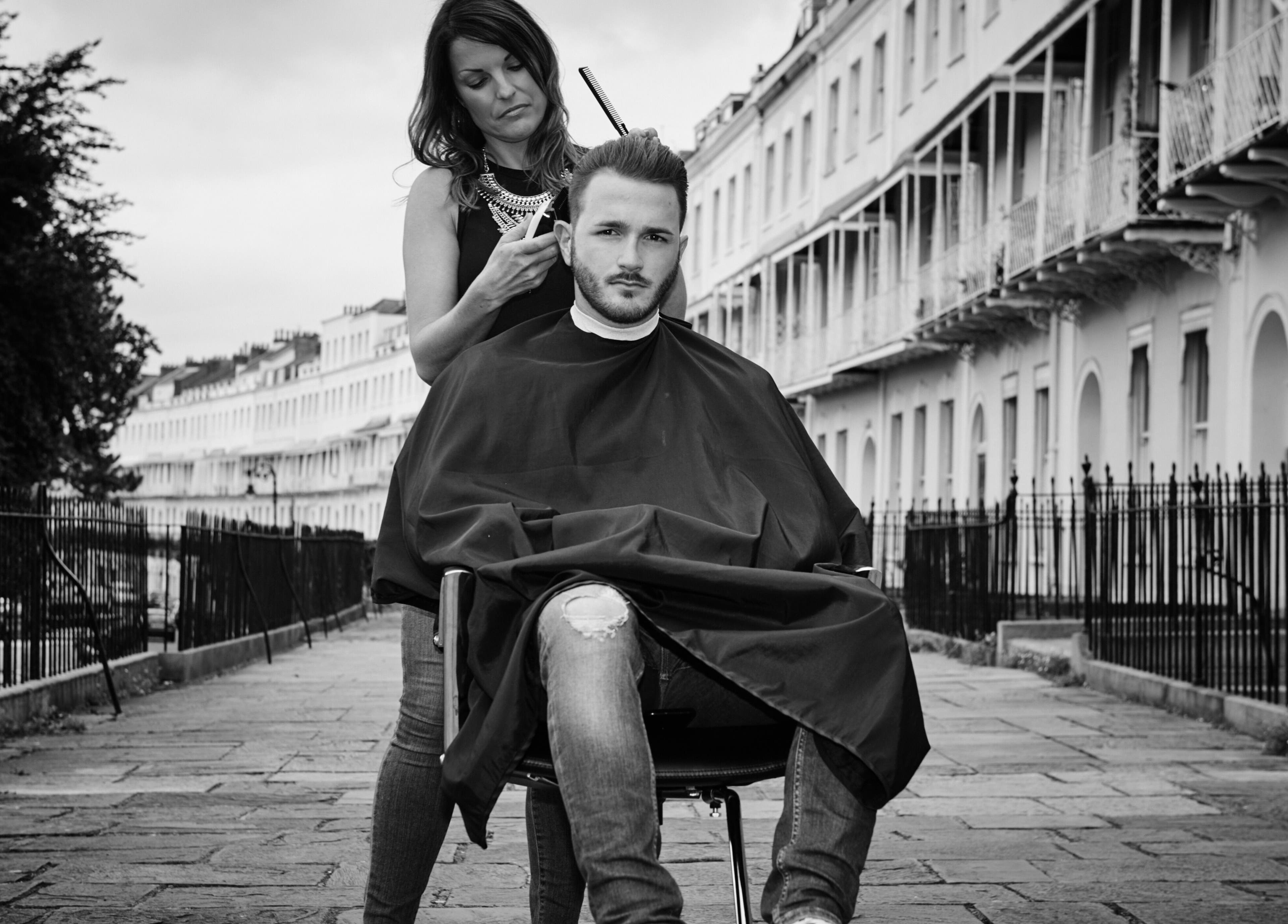 Rachael the Barber at Aiden Garlington Hair Design styling hair outdoors in Bristol, England, GB.