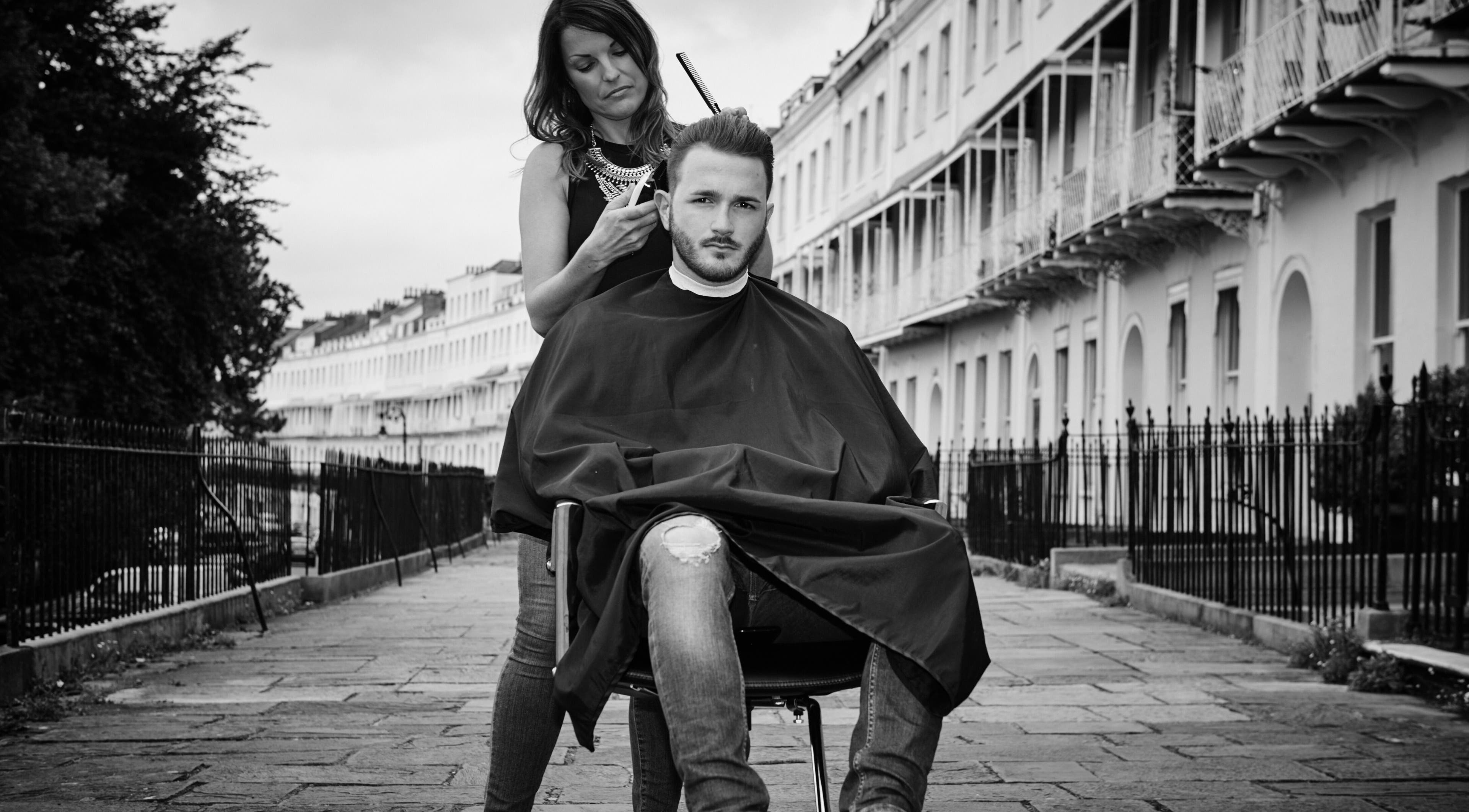 Rachael the Barber at Aiden Garlington Hair Design styling hair outdoors in Bristol, England, GB.