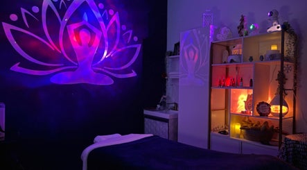 Peaceful massage room at Marvella Bliss, Pembroke Pines, Florida, lit by soothing purple and red lights.