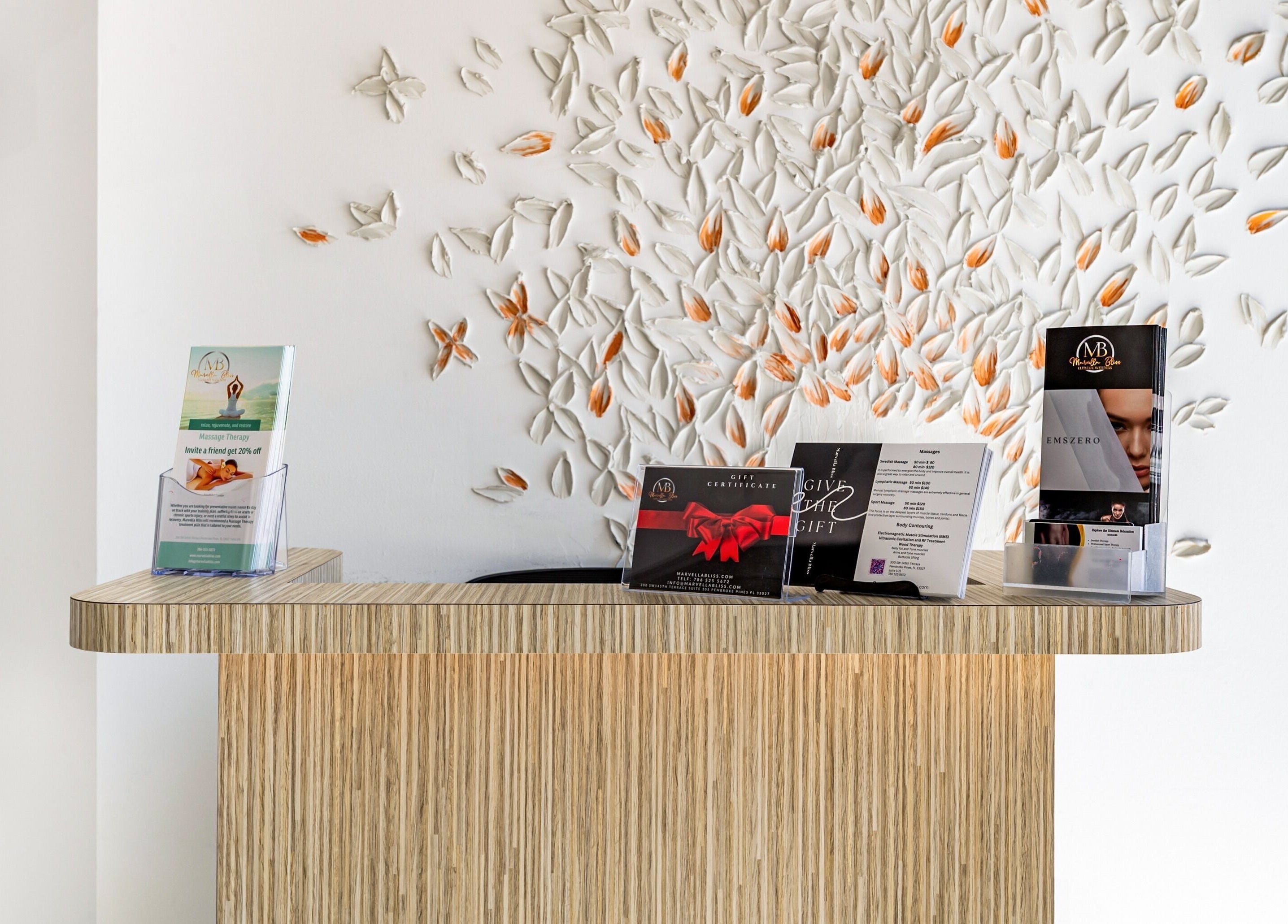 Reception desk at Marvella Bliss with decorative leaf wall in Pembroke Pines, Florida, US.