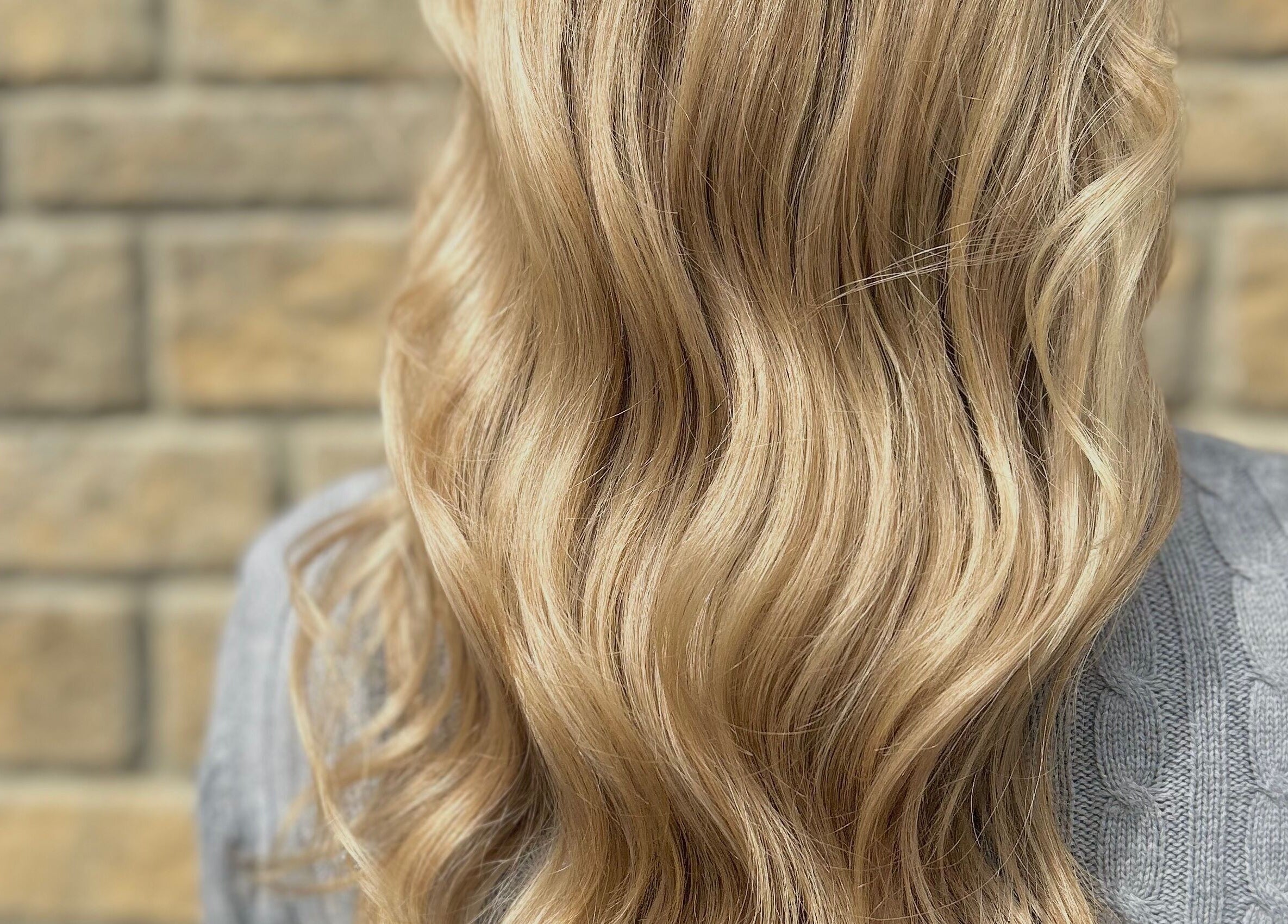 Flowing blonde hair styled at Hair by Éloise, Lyneham, England, GB. Perfect waves add elegance and charm.