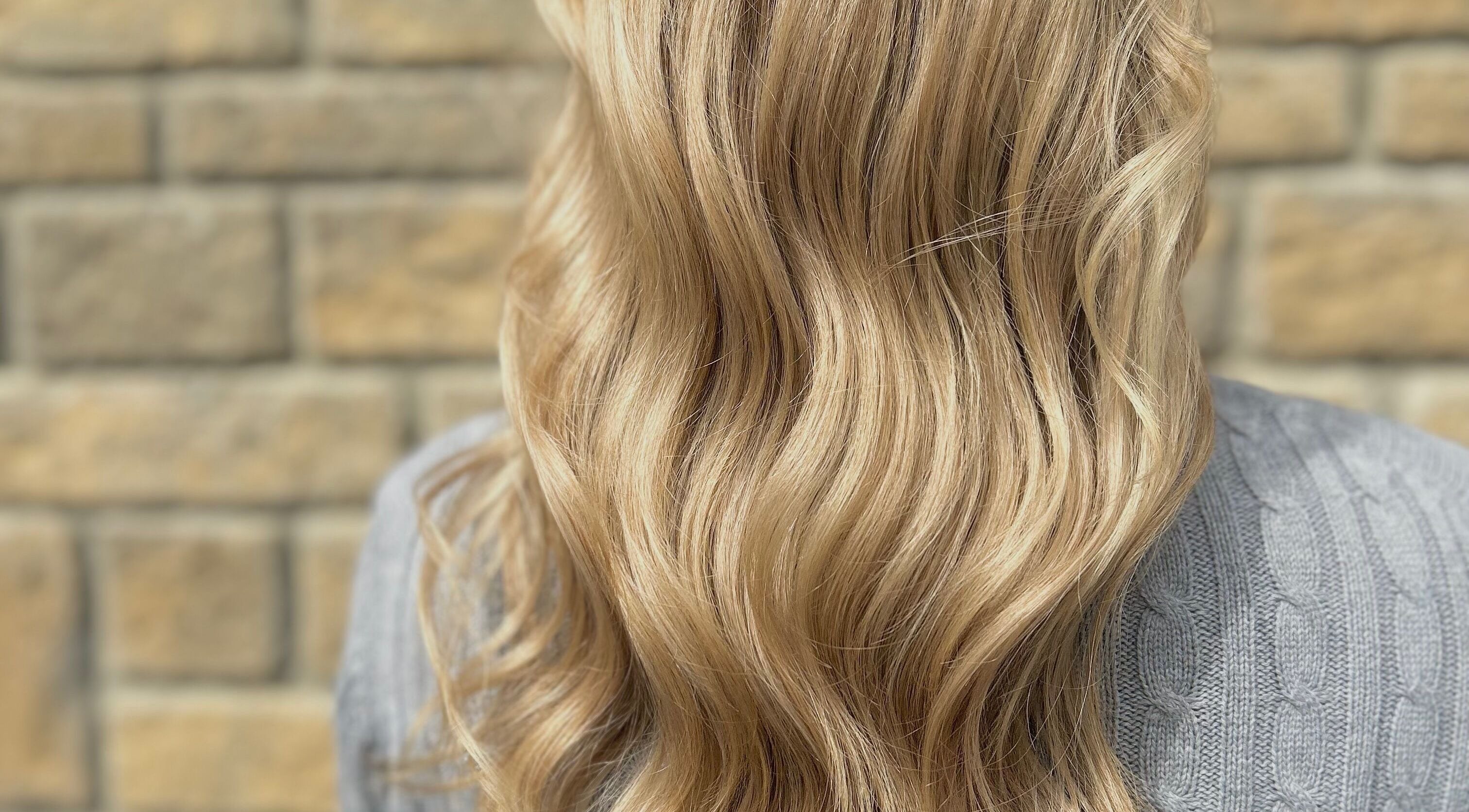 Flowing blonde hair styled at Hair by Éloise, Lyneham, England, GB. Perfect waves add elegance and charm.