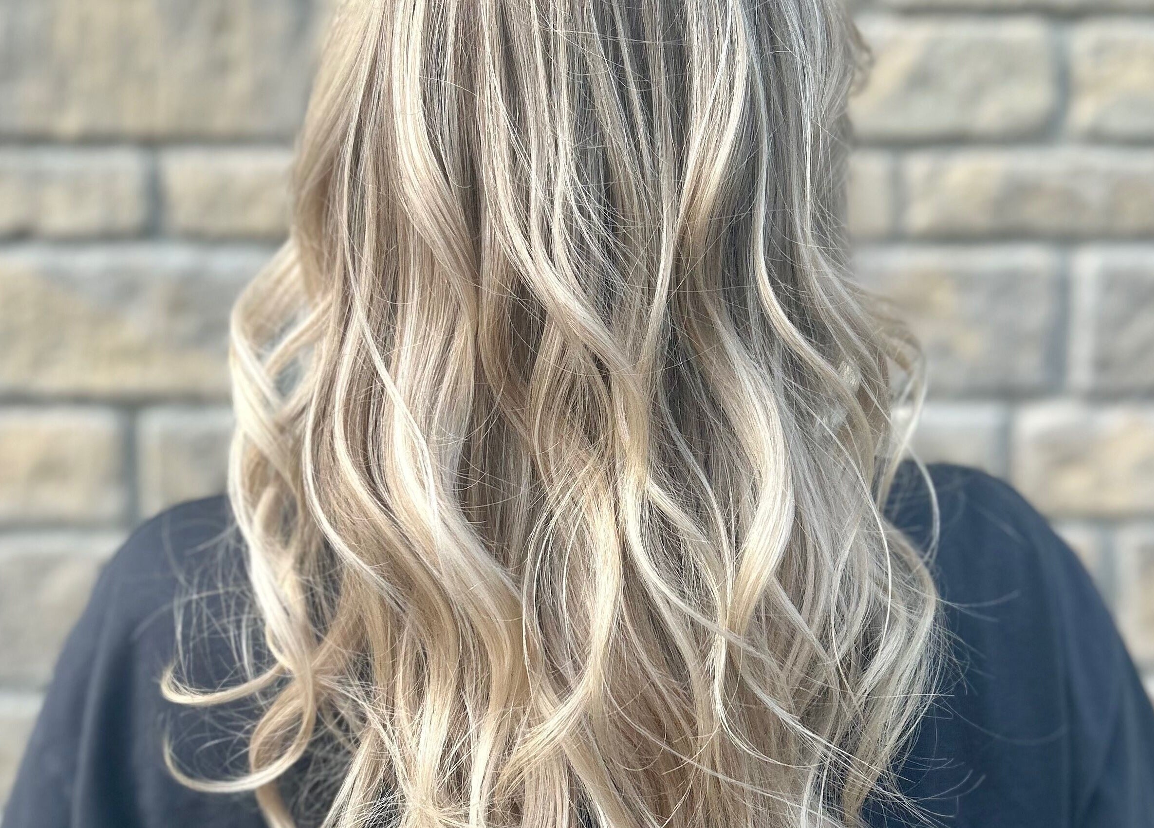 Long, wavy blonde hair styled beautifully at Hair by Éloise, Lyneham, England, GB.