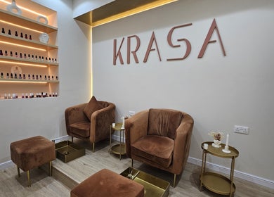 Elegant lounge area at Krasa Facial Center, Dubai, AE with brown chairs and nail polish display.