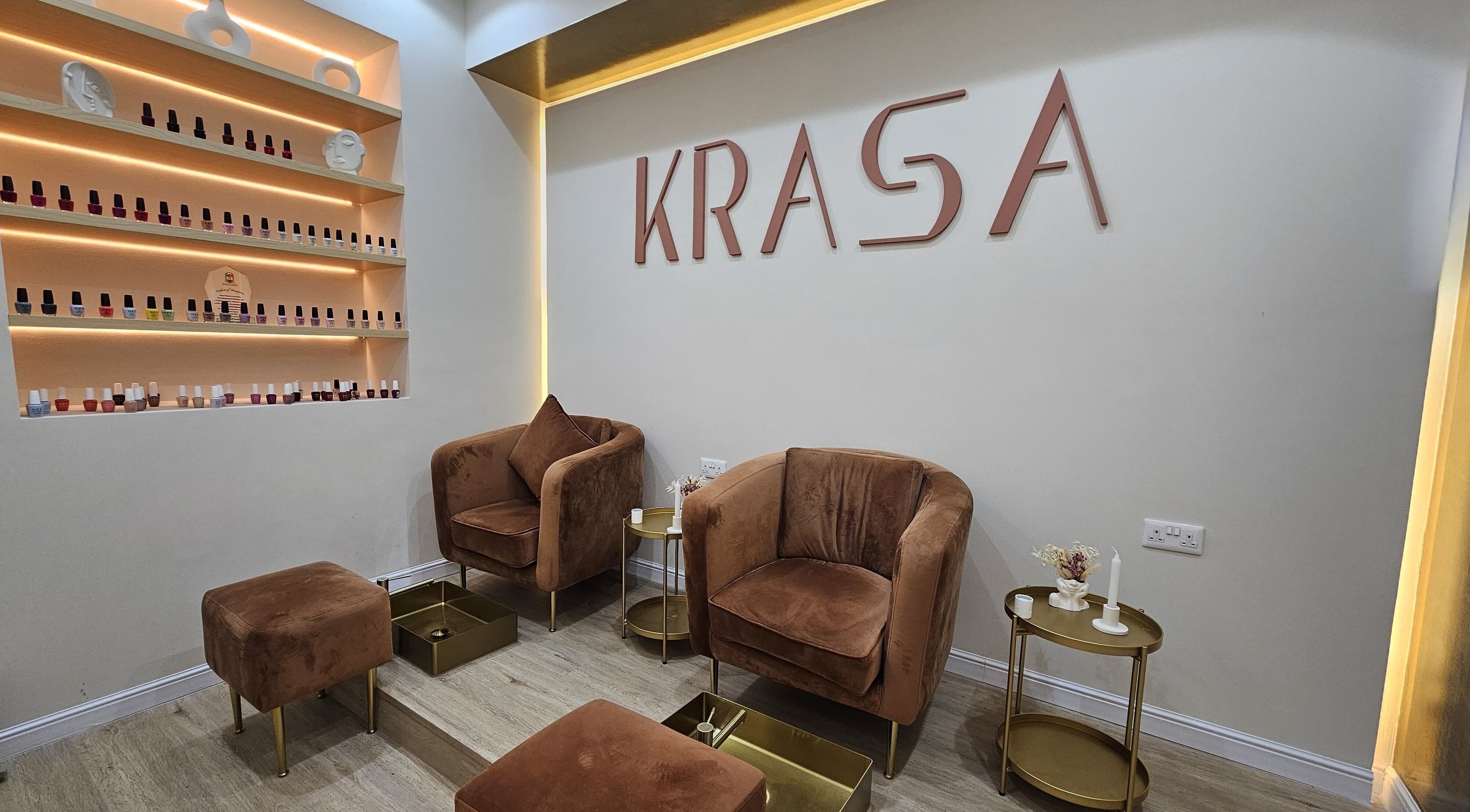 Elegant lounge area at Krasa Facial Center, Dubai, AE with brown chairs and nail polish display.