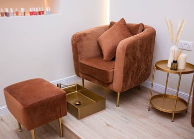 Elegant pedicure chair at Krasa Facial Center, Dubai, AE, with nail polishes and side table decor.
