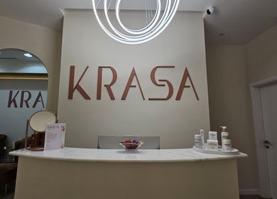 Krasa Facial Center reception area in Dubai, AE, showcasing modern decor and skincare products.