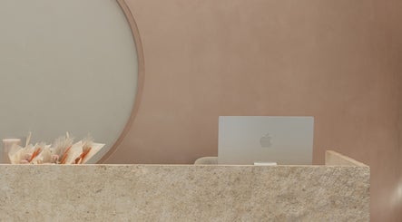 Reception desk at Stellar Salon in Riyadh, Riyadh Province, SA with stone finish and laptop.