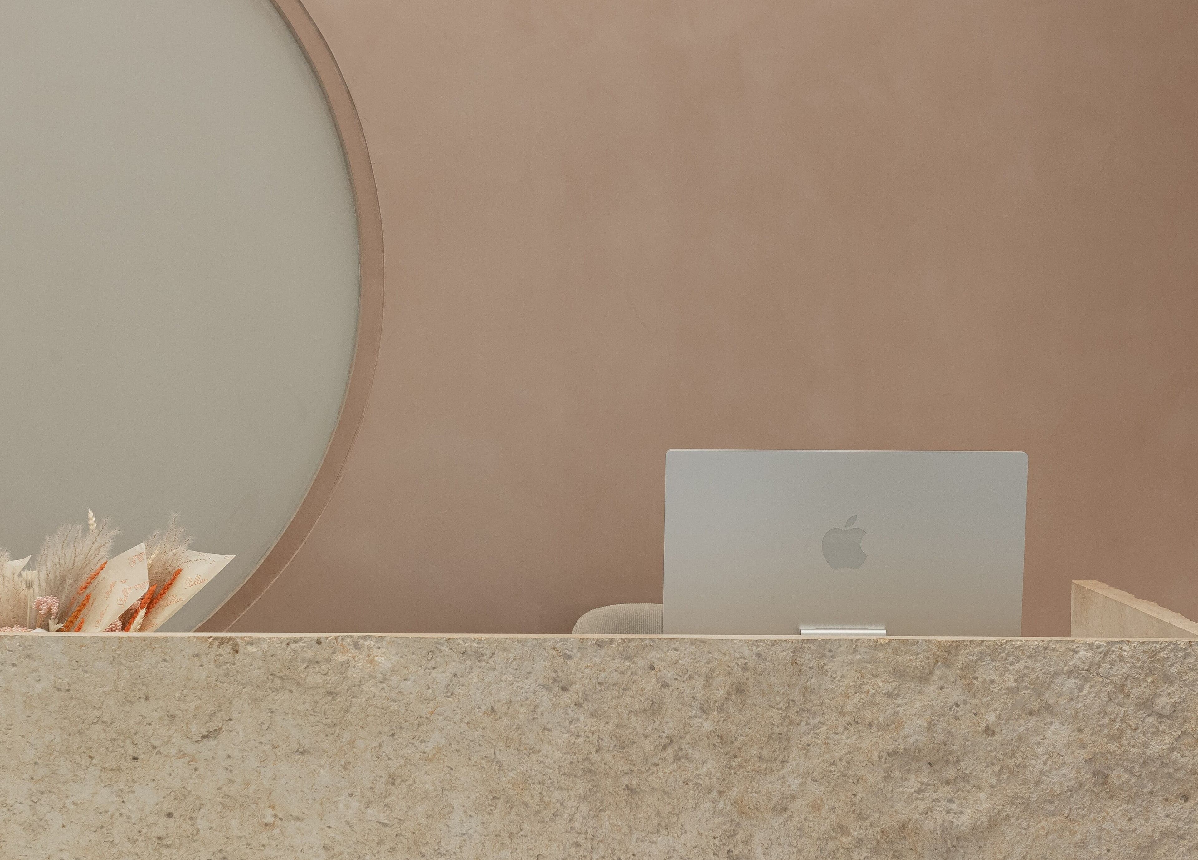 Sleek reception desk at Stellar Salon, Riyadh, Riyadh Province, SA, with elegant decor and a laptop.