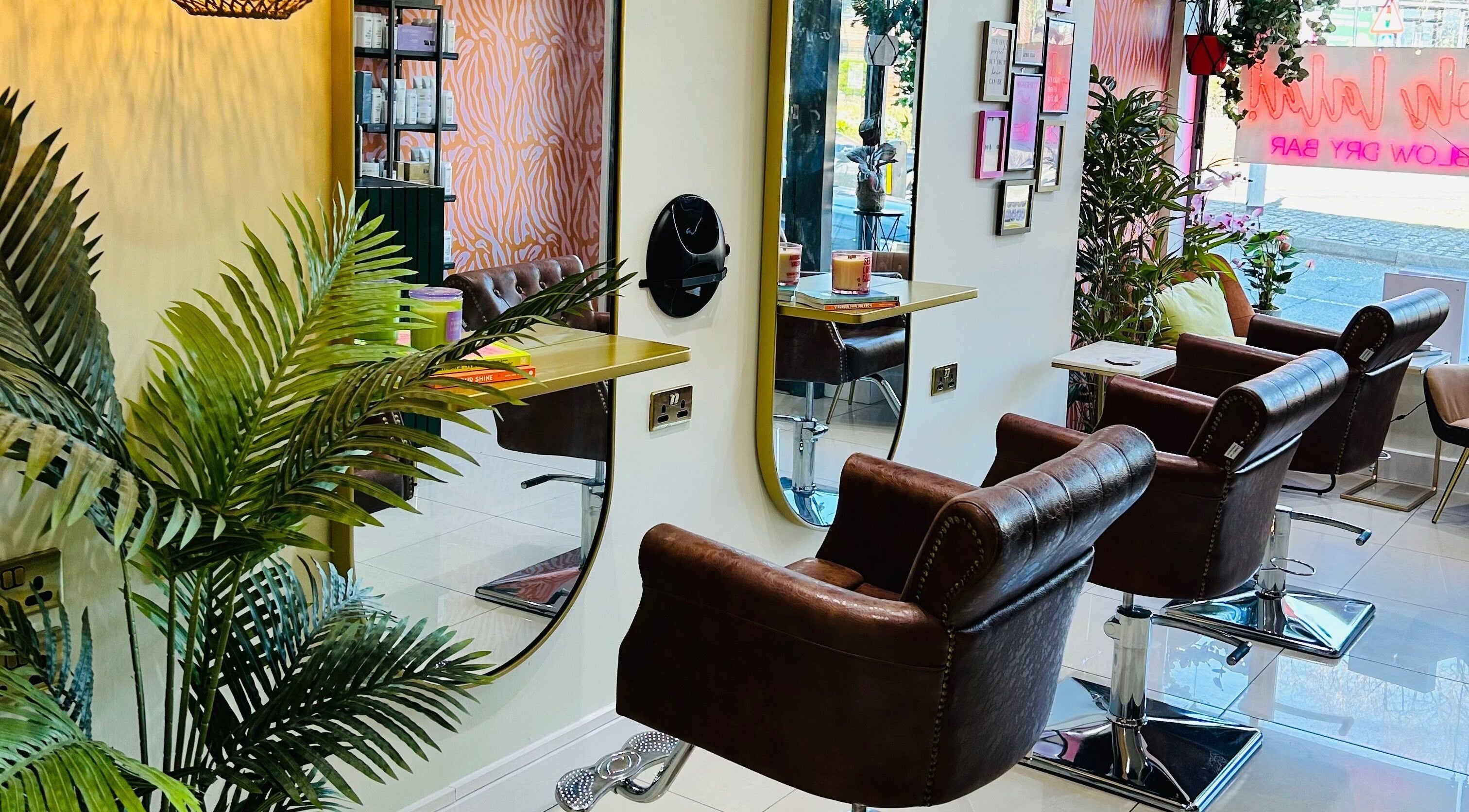 Interior of Ooh La La Blow Dry Bar in Stone, England, GB featuring stylish salon chairs and large mirrors.