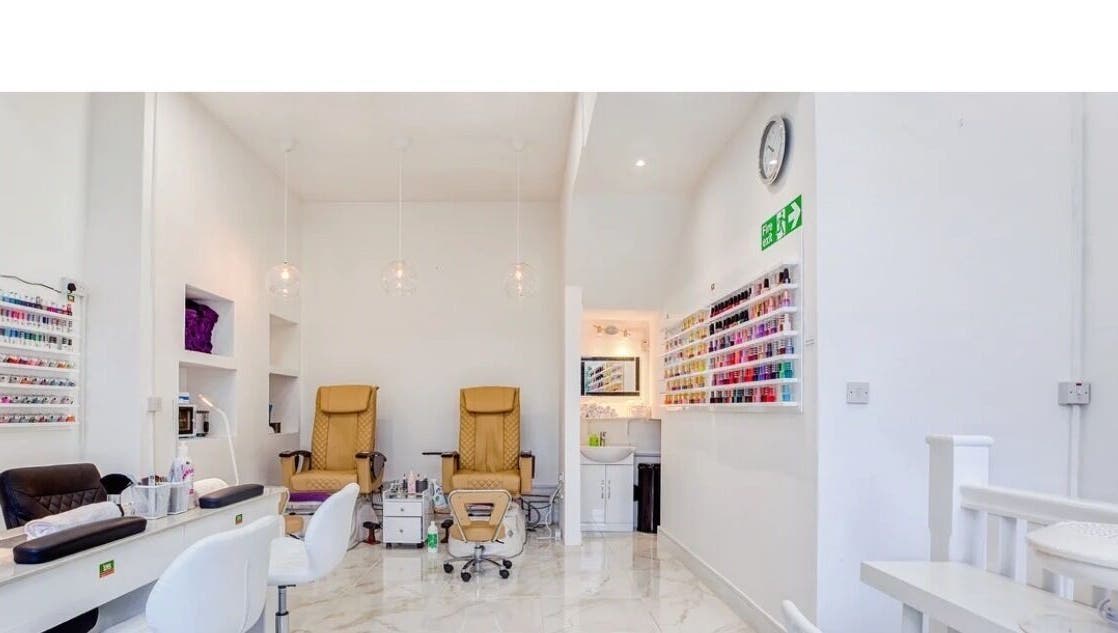 Interior of DK Nails Roehampton in London, England, GB featuring plush chairs and a nail polish display.