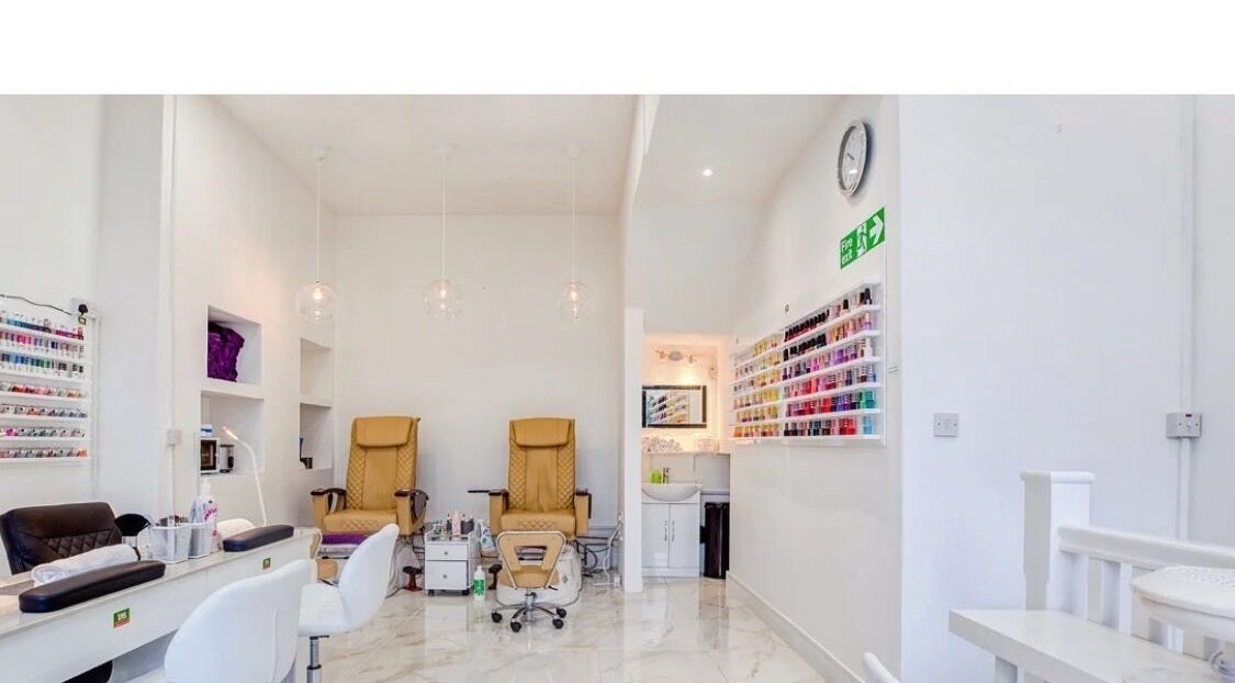 Interior of DK Nails Roehampton in London, England, GB featuring plush chairs and a nail polish display.
