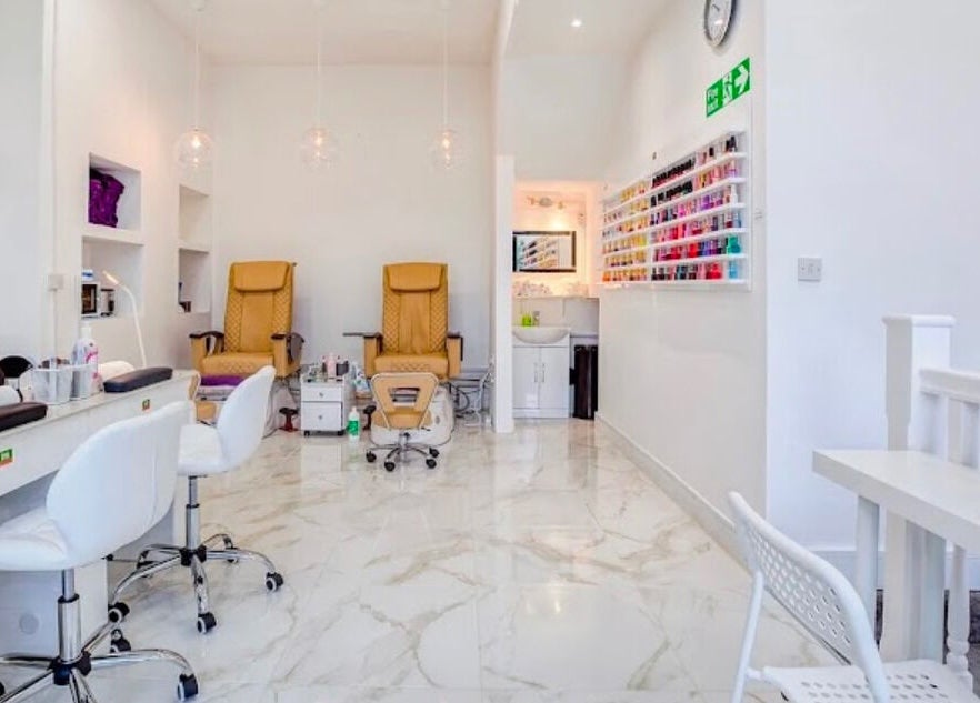 Modern interior of DK nails Roehampton, London, England, GB, showcasing elegant chairs and nail polish display.