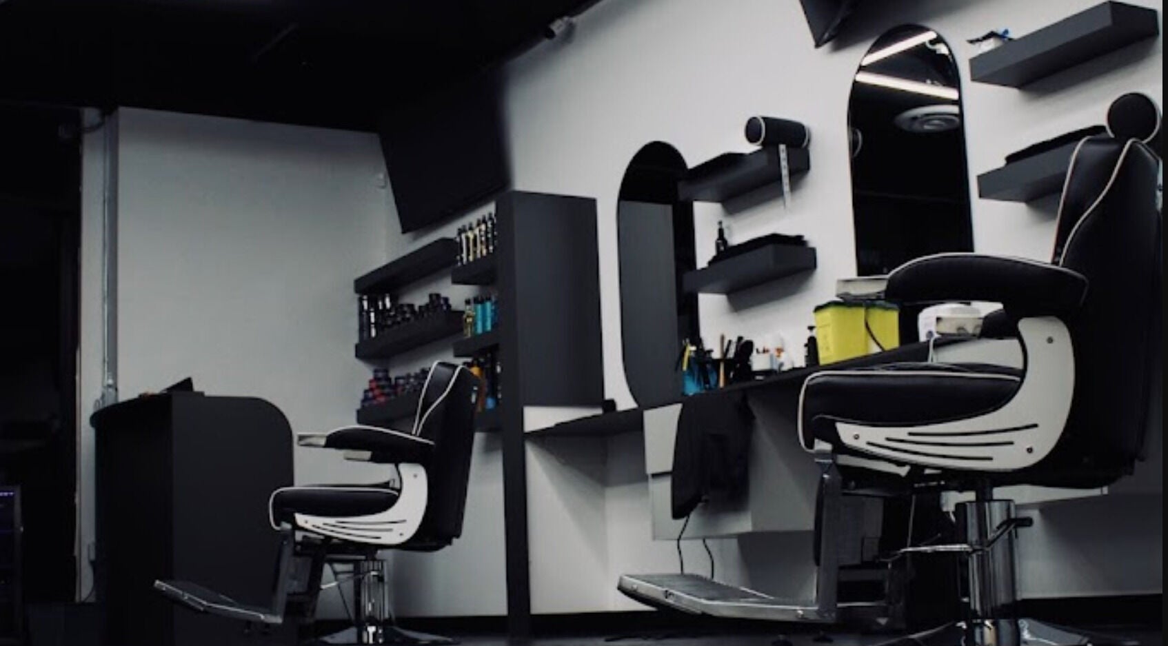 Elegant interiors of Platinum Barbershop in Edmonton, Alberta, CA featuring modern barber chairs and shelves.