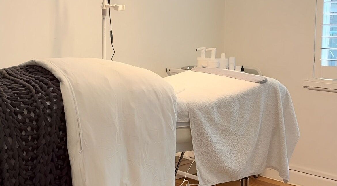 Cozy treatment room at STK Beauty House in Melbourne, Victoria, AU with white towels and skincare products.