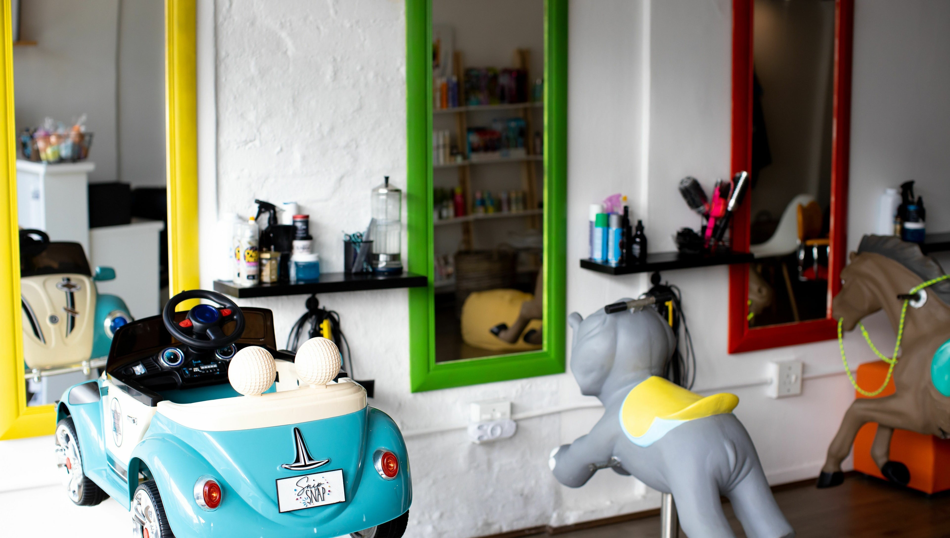 Child-friendly salon with toy cars and mirrors at Snip Snap, Newlands, Cape Town, Western Cape, ZA.