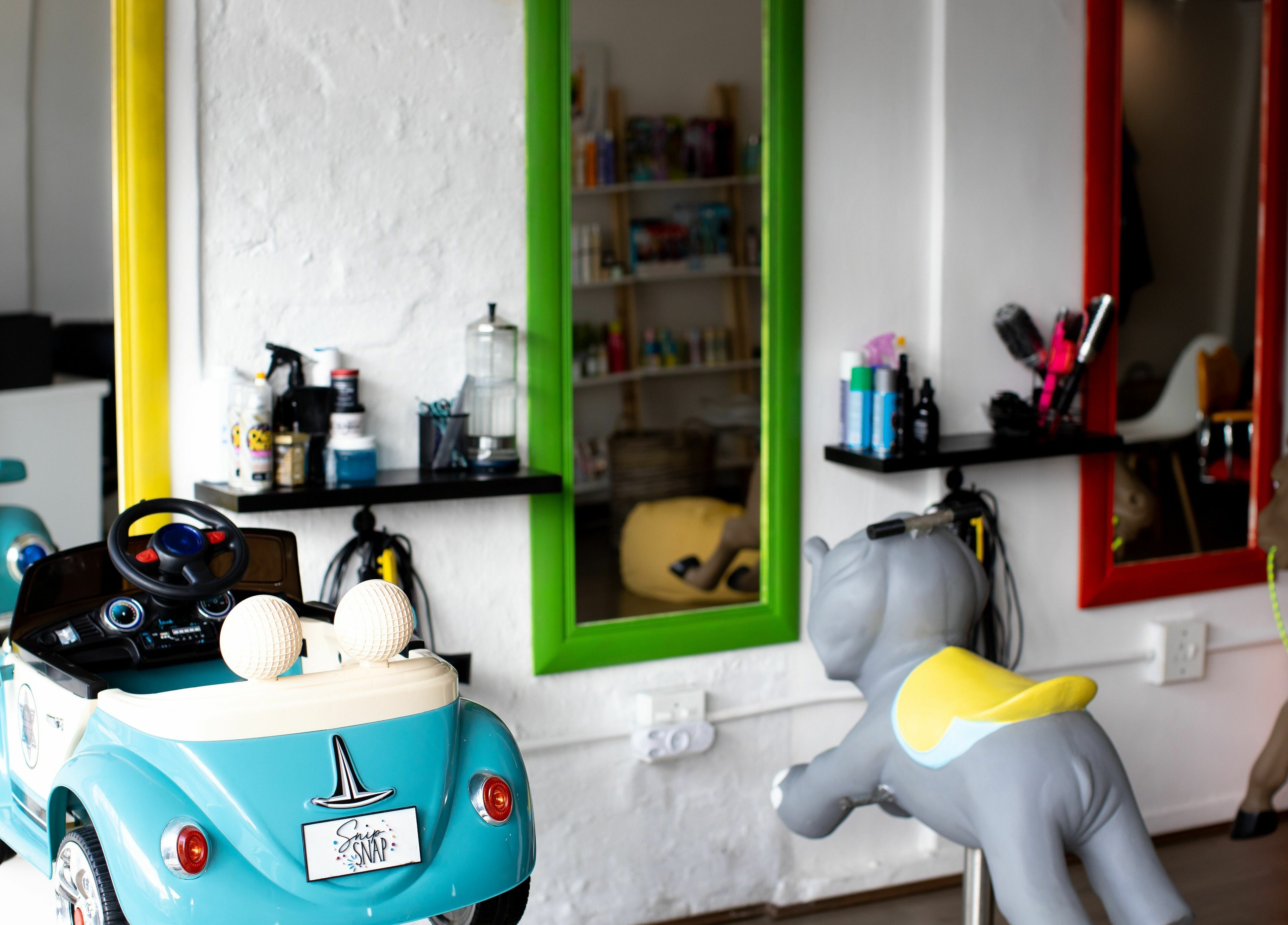 Child-friendly salon with toy cars and mirrors at Snip Snap, Newlands, Cape Town, Western Cape, ZA.