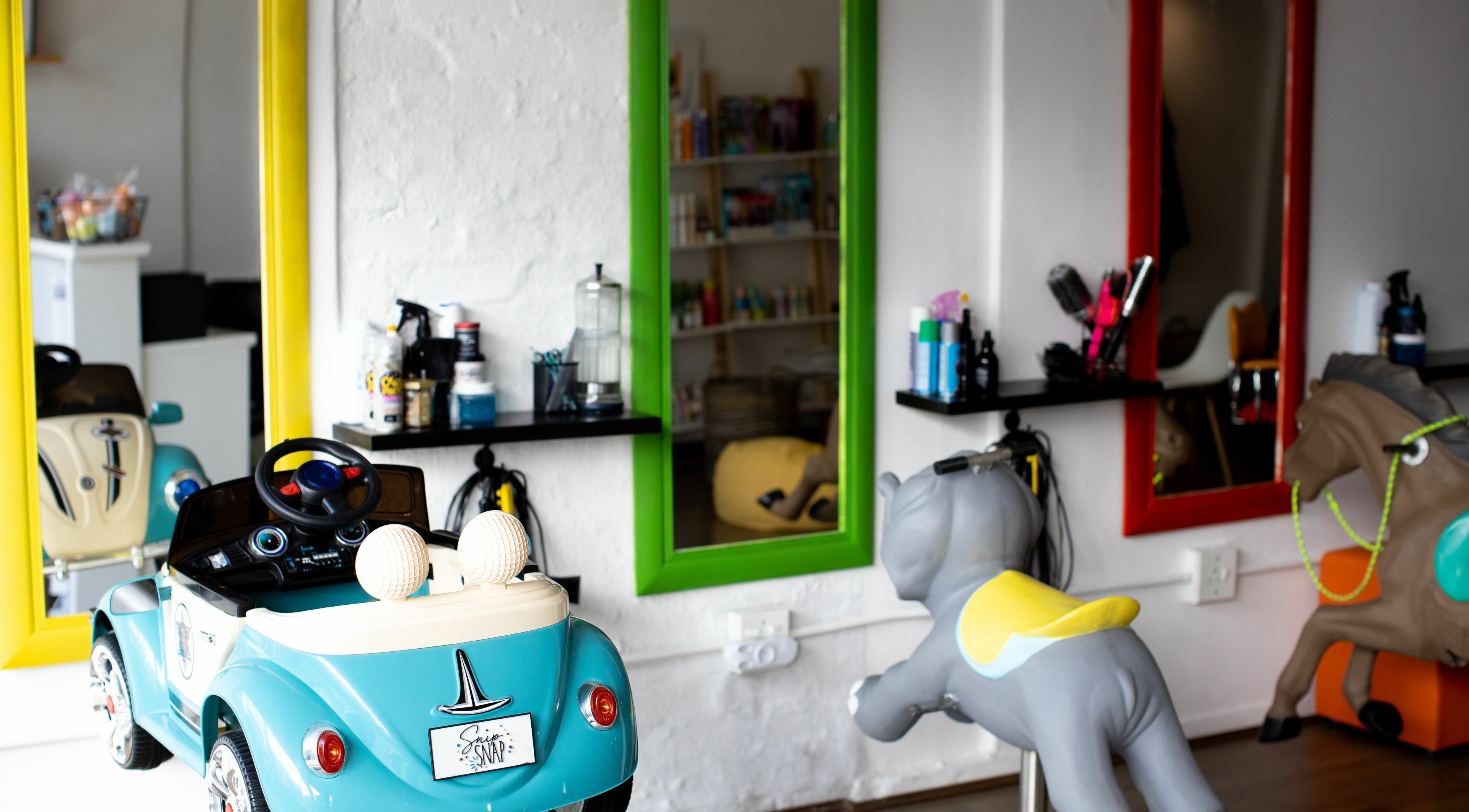 Child-friendly salon with toy cars and mirrors at Snip Snap, Newlands, Cape Town, Western Cape, ZA.