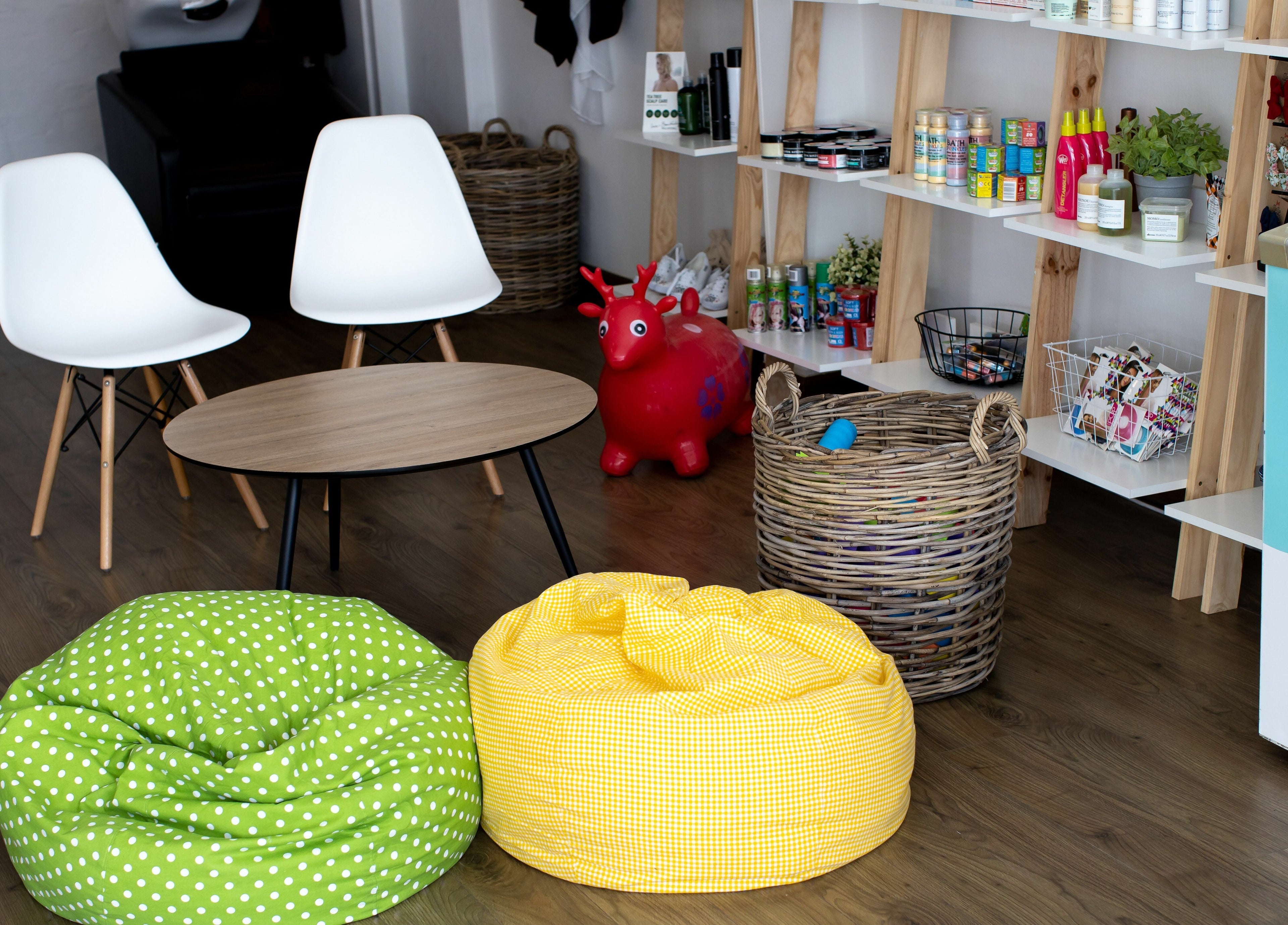 Relaxing lounge area at Snip Snap, Newlands, Cape Town with bean bags and wooden shelves.