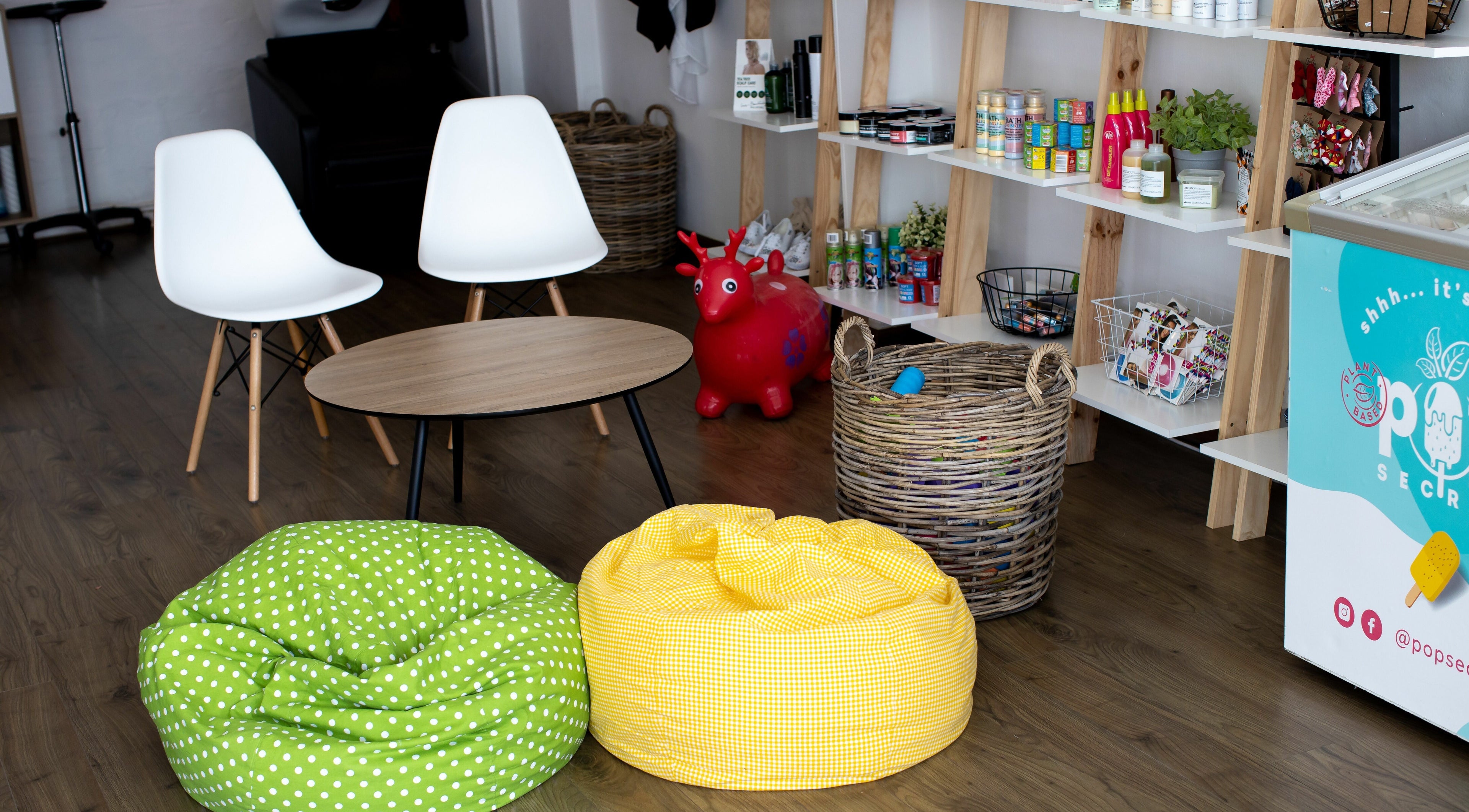 Relaxing lounge area at Snip Snap, Newlands, Cape Town with bean bags and wooden shelves.