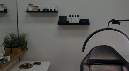 Chic treatment room at Arch Envy, Daventry, England, GB with modern decor and a comfy black chair.