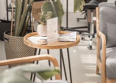 Cozy seating area at Kēp Esthetique, Montréal, Québec, CA with gray chairs and a wooden table with plant decor.
