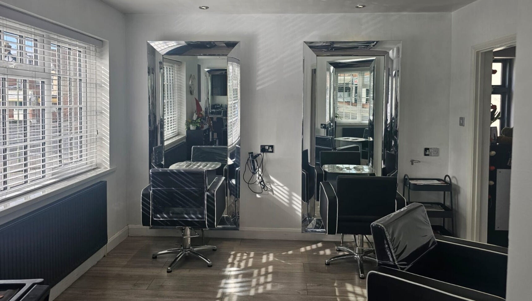 Sleek chairs and mirrors at Hideaway Hair Salon, Park Gate, England, GB, showcasing elegant salon design.