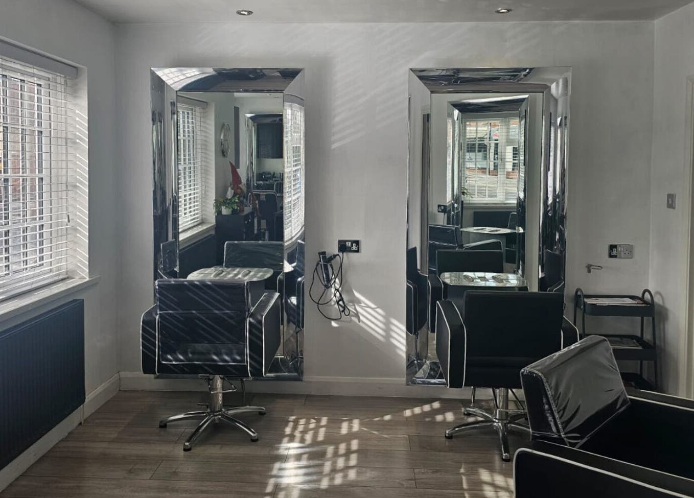 Sleek chairs and mirrors at Hideaway Hair Salon, Park Gate, England, GB, showcasing elegant salon design.